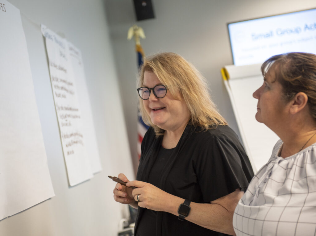 two women looking at a whiteboard